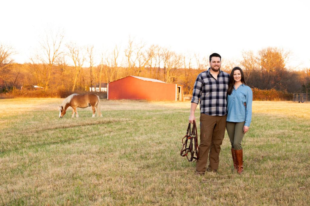 man and woman stand in a pasture