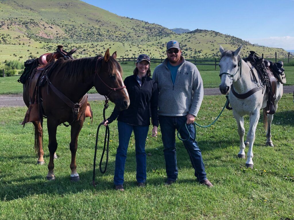 Man and woman standing next to horses