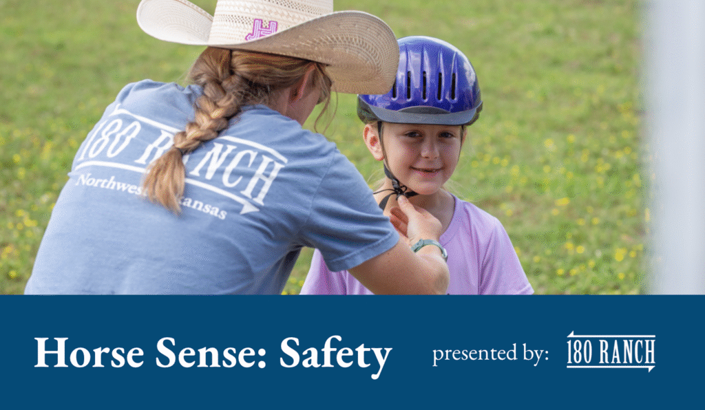 Woman in blue t shirt and cowgirl hat adjusts a purple riding helmet on a little girl in a purple t shirt